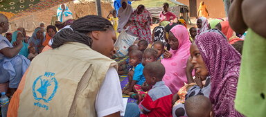 WFP/Agron Dragaj сотрудник разговаривает с людьми, получающими помощь